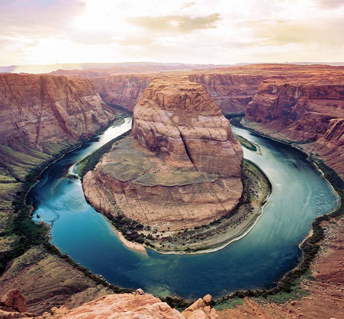 An aerial view of a river bending between tall canyon cliffs.