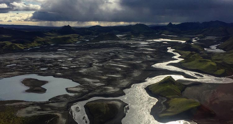 An aerial view of a river meandering through a rolling landscape.