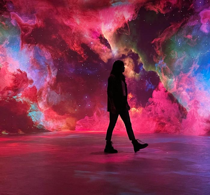 A person walks through a galaxy art display.