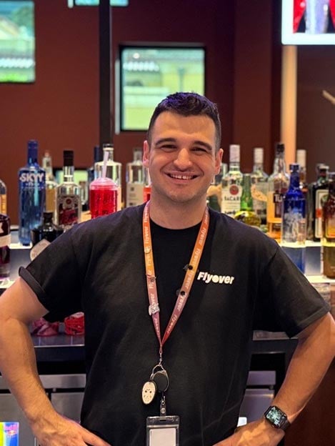 Blade, a bartender, stands at the bar at Flyover in Las Vegas.